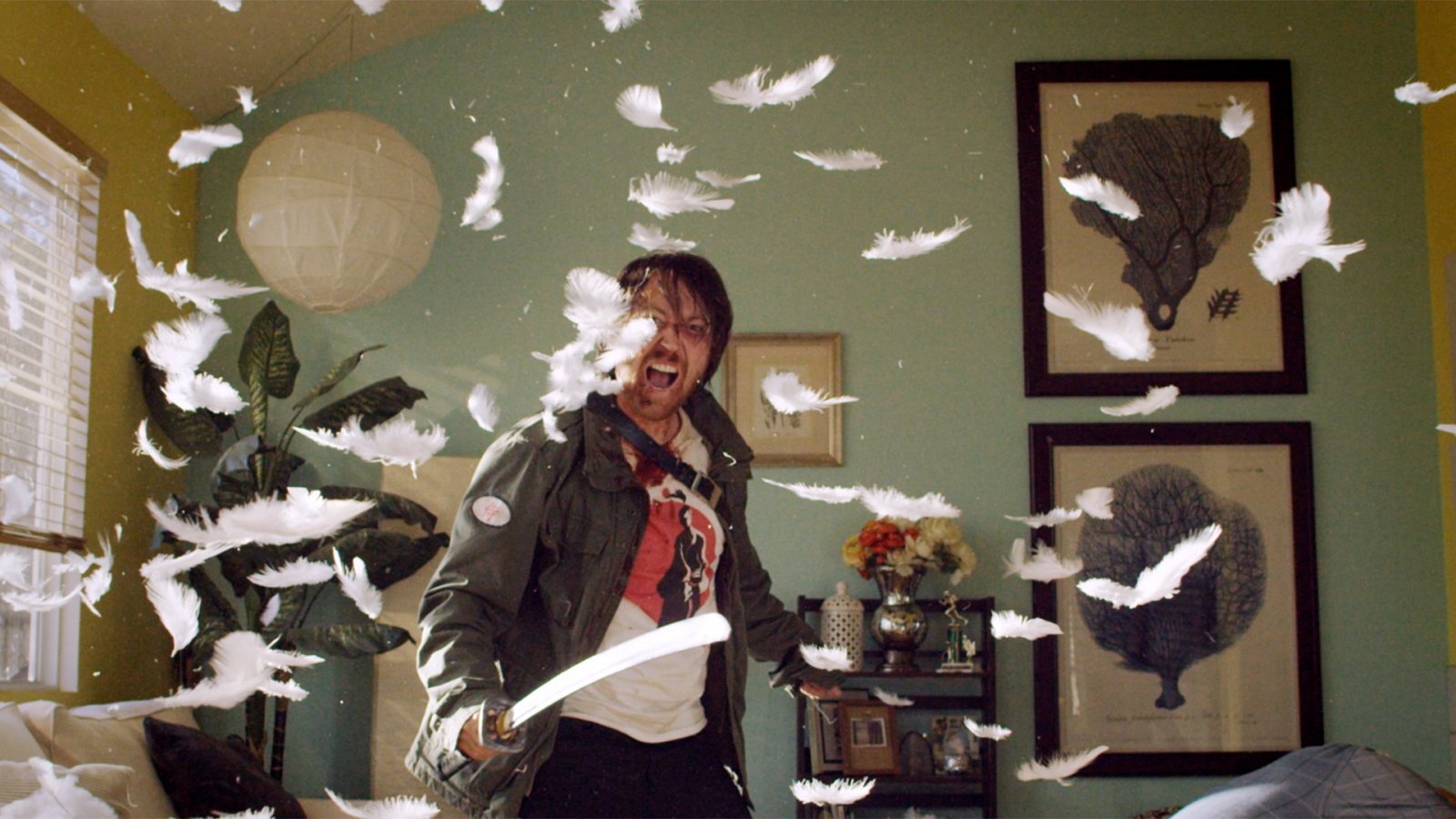 Man wielding a sword and screaming mid-fight in a living room filled with flying feathers